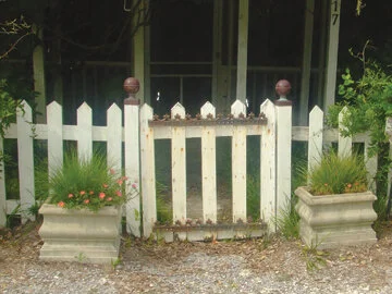 Cement planters anchor this gate and further define the entrance.  Photo by Al Smoczynski